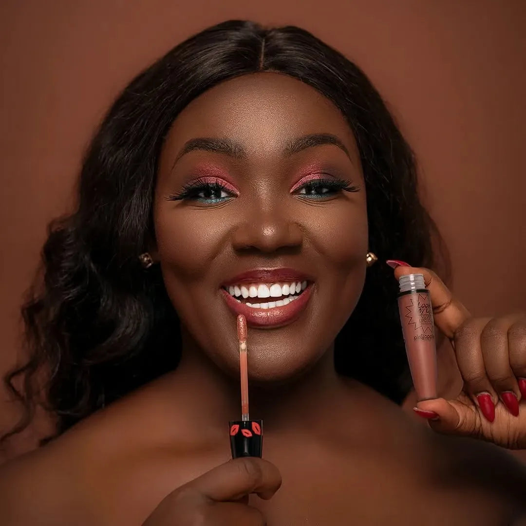 Smiling woman using lipgloss