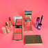 Makeup products including lipsticks, blushes, and a compact mirror on a pink background